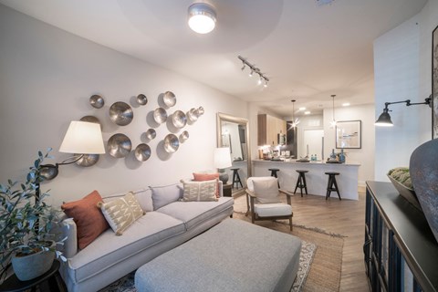 a living room with a white couch and a bar in the background